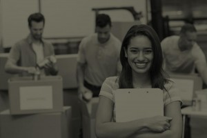 woman holding clipboard and men at her back putting things in boxes
