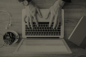 black and white hands typing in a laptop