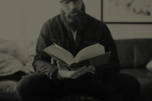 black and white photo of man reading a book