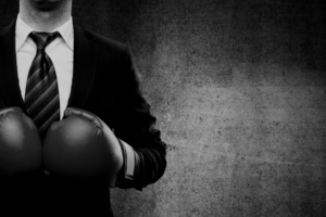 black and white photo of man in suit wearing boxing gloves