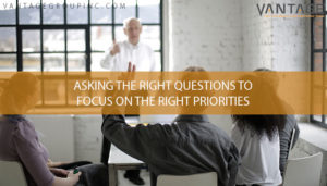 Man having a meeting with his team with text reading asking the right questions to focus on the right priorities