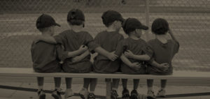 kids in baseball team having each other's back